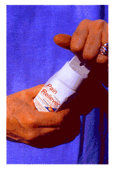 Hands opening pain reliever bottle.